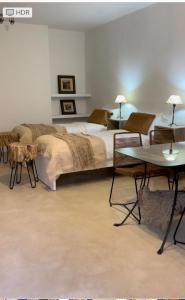 1 dormitorio con 1 cama y 2 mesas y sillas en Casa de Piedra- céntrica en La Rioja