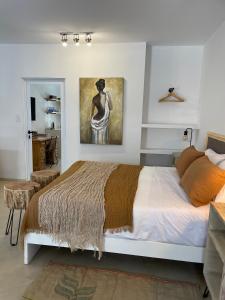 1 dormitorio con 1 cama y una pintura en la pared en Casa de Piedra- céntrica en La Rioja