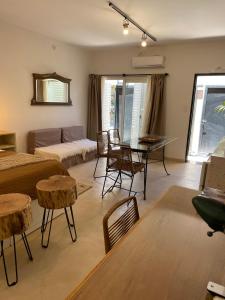 uma sala de estar com uma cama, uma mesa e cadeiras em Casa de Piedra- céntrica em La Rioja
