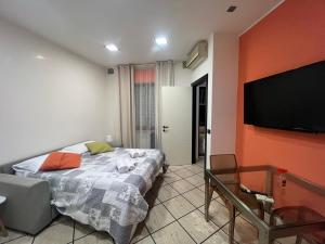 Schlafzimmer mit einem Bett und einem Flachbild-TV in der Unterkunft SUITE Asterope in Francavilla al Mare