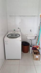 una pequeña cocina con lavadora y fregadero en CASA 2 QUARTOS en Río de Janeiro