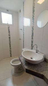 een witte badkamer met een wastafel en een toilet bij CASA 2 QUARTOS in Rio de Janeiro