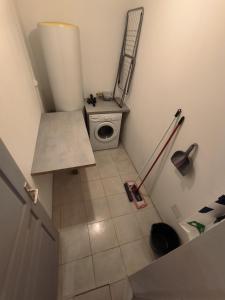 y baño pequeño con aseo y lavadora. en Superbe appartement, en Lamalou-les-Bains