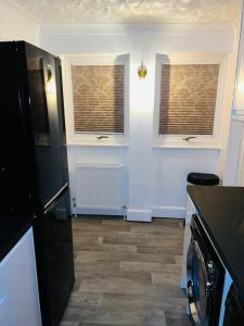 a kitchen with two windows and a counter top at Ensuite Luxury Bedroom In Purfleet in Purfleet
