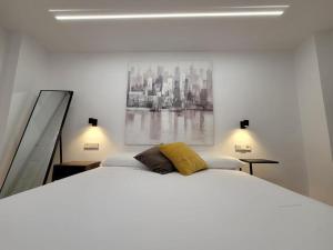 1 dormitorio con 1 cama blanca y una pintura en la pared en Lemon & Muralla -Céntrico-Nuevo-Premium, en Murcia