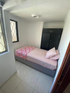 Cette petite chambre comprend un lit avec des draps roses. dans l'établissement Apartamento en cartagena, à Carthagène des Indes