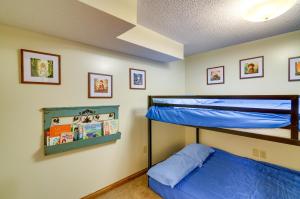 1 dormitorio con litera y 1 cama azul en Burnside Resort Cabin with Hot Tub and Outdoor Spots!, en Burnside