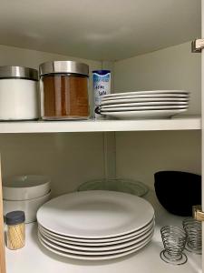 a shelf with plates and other dishes on it at Cronenberger Apartment mit Garten - kontaktloses Einchecken, Netflix, Kingsize-Bett in Wuppertal