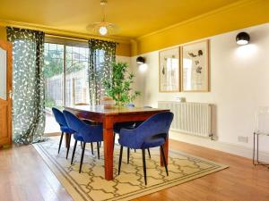 a dining room with a wooden table and blue chairs at Stylish 3 Bed Home with Parking! in Cardiff