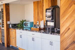 a kitchen with white cabinets and a black counter top at Hotel La Croix in Honolulu