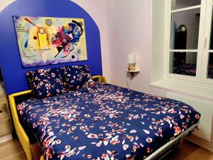 a bedroom with a bed and a painting on the wall at Golden Art Studio in Saint-Germain-en-Laye