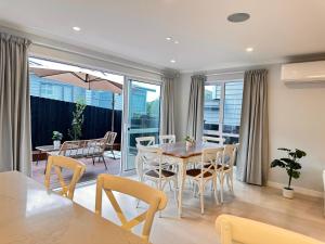 - une salle à manger avec une table et des chaises dans l'établissement 123B Forresthill Rd, à Auckland