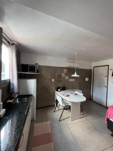 una pequeña cocina con una mesa blanca en una habitación en STUDIO 303 | WIFI 600MB | RESIDENCIAL JC, um lugar para ficar. en Belém