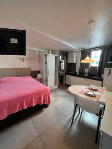 a bedroom with a bed and a table and a kitchen at STUDIO 303 | WIFI 600MB | RESIDENCIAL JC, um lugar para ficar. in Belém