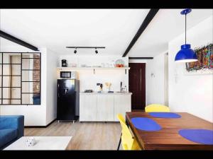 uma cozinha e sala de jantar com uma mesa e um frigorífico em Stylish 2BR Chapinero Apt - Prime Location! em Bogotá