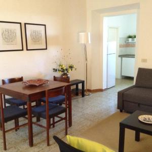 a living room with a table and chairs and a couch at Casa Anna in Castagneto Carducci