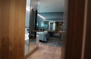 a view of a room with a bed and a mirror at Empire Beach Resort ADULTS ONLY in Dhërmi