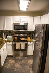 a kitchen with white cabinets and a stainless steel refrigerator at Family Friendly - Sleeps 6 - King Bed in Incline Village