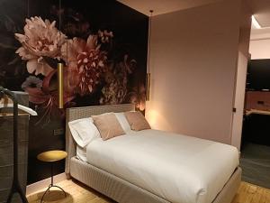 una camera con un letto bianco e una parete fiorita di 13 Suites Conde a León
