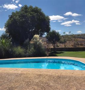 een blauw zwembad in een tuin met bomen bij Charming Casa Rural El Pedregal 