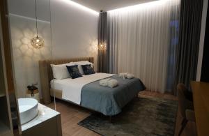 a bedroom with a bed and a tub and a sink at Empire Beach Resort ADULTS ONLY in Dhërmi