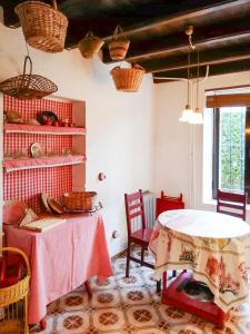 een kamer met een tafel met stoelen en manden aan de muur bij Charming Casa Rural El Pedregal 