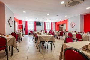 restauracja ze stołami, krzesłami i czerwonymi ścianami w obiekcie Hotel Ristorante La Mimosa w mieście Lamezia Terme