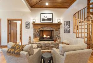 a living room with a stone fireplace with two chairs at 4 Pines in Boone