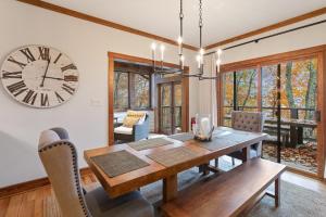 a dining room with a table and a clock on the wall at 4 Pines in Boone
