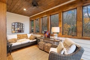 a living room with a couch and chairs and windows at 4 Pines in Boone +33 photos