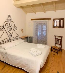 een slaapkamer met een groot wit bed en handdoeken bij Charming Casa Rural El Pedregal 