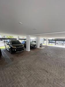 two cars are parked in a parking lot at Loft Luxo para 4 pessoas vista mar in Cabedelo