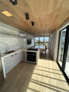 a kitchen with a stove top oven in a room at Loft Luxo para 4 pessoas vista mar in Cabedelo