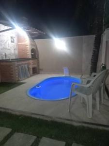 a swimming pool with a blue tub in a room at Casa em Unamar, Cabo Frio - com piscina privativa in Cabo Frio