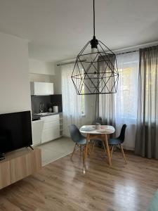 a living room with a table and chairs and a television at Apartmán "DUNAJ" in Šamorín