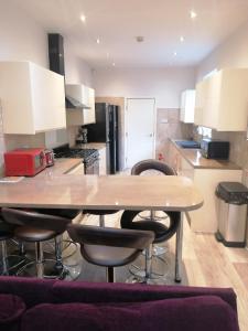 cocina con mesa de madera y taburetes en Great Home of Relaxations en Stoke on Trent
