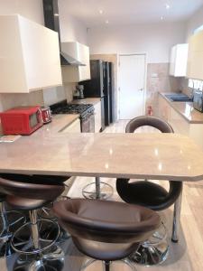 a kitchen with a table and stools in it at Great Home of Relaxations in Stoke on Trent