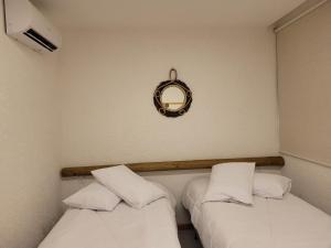 聖米格爾－杜斯米拉格里斯的住宿－Villa Kamby 101B Milagres , ao lado da Capela dos Milagres，两张位于墙上镜子的床铺