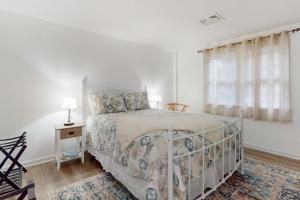 um quarto branco com uma cama e uma janela em Foxglove on Cape em Centerville