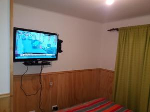 uma televisão de ecrã plano pendurada numa parede em ACOGEDOR DEPARTAMENTO em Puerto Montt