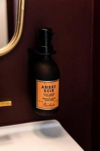 a bottle of acne sauce sitting on a bathroom sink at Mr. Nomad: Parisian PopHaus in Uptown in Dallas