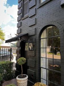 a black brick building with a plant in a pot at Mr. Nomad: Parisian PopHaus in Uptown in Dallas