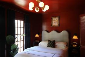 a bedroom with a white bed with red walls at Mr. Nomad: Parisian PopHaus in Uptown in Dallas