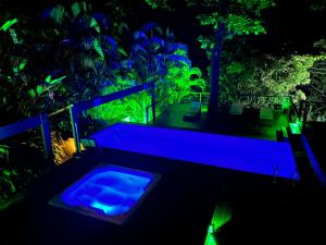 una piscina en la oscuridad con luces azules en Casas Do Mar, en Ilhabela