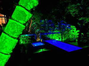 an outdoor patio with blue and green lights at Casas Do Mar in Ilhabela