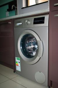 Eine Waschmaschine befindet sich in einem Zimmer in der Unterkunft Candymoore apartment in Sandton