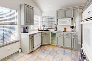 a kitchen with white cabinets and a tile floor at Big City Living, Full Property in Dallas