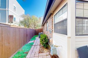 a fence next to a house with a white door at Big City Living, Full Property in Dallas