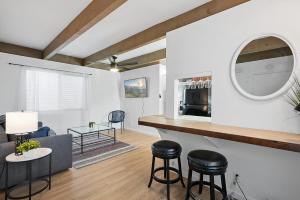 a kitchen and living room with a counter and stools at Mission Bay Condo - Steps to Sand, Dining, AC, Parking & Shops! in San Diego