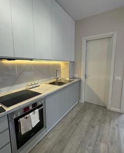 an empty kitchen with white cabinets and a sink at SC Tirana Centre Apartment in Tirana